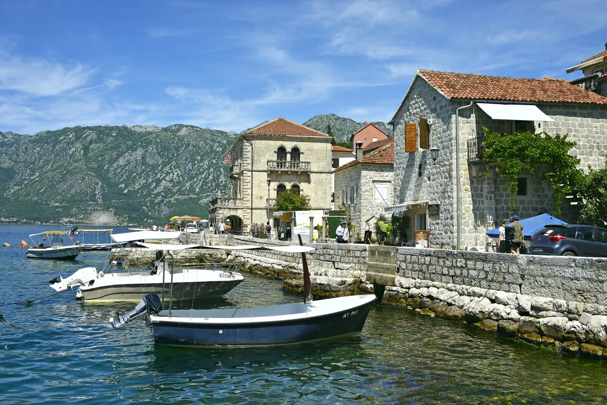 Il lungomare di Perast con barche e i palazzi di pietra delle famiglie di marinai