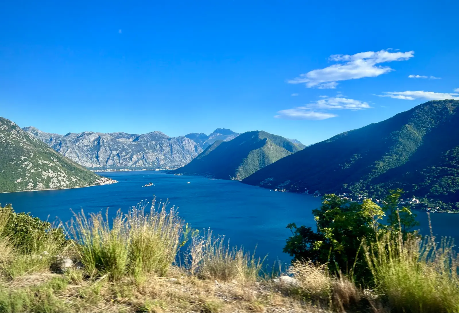 Blick auf die Bucht von Kotor von der Küstenstraße E65 bei Morinj: türkisfarbenes Wasser, Berge im Hintergrund