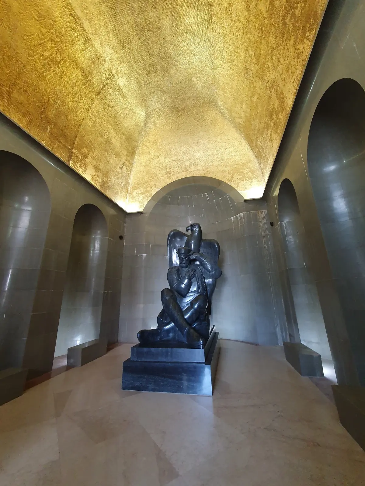 Meštrović's granite figure of Njegoš with an eagle, under the gilded vault of the mausoleum