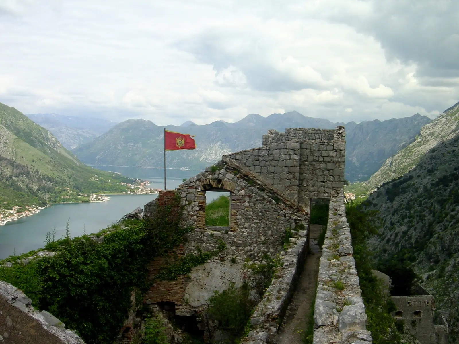 Vista panorámica aérea de la Bahía de Kotor y la Ciudad Vieja de Kotor, con las murallas visibles ascendiendo por la montaña