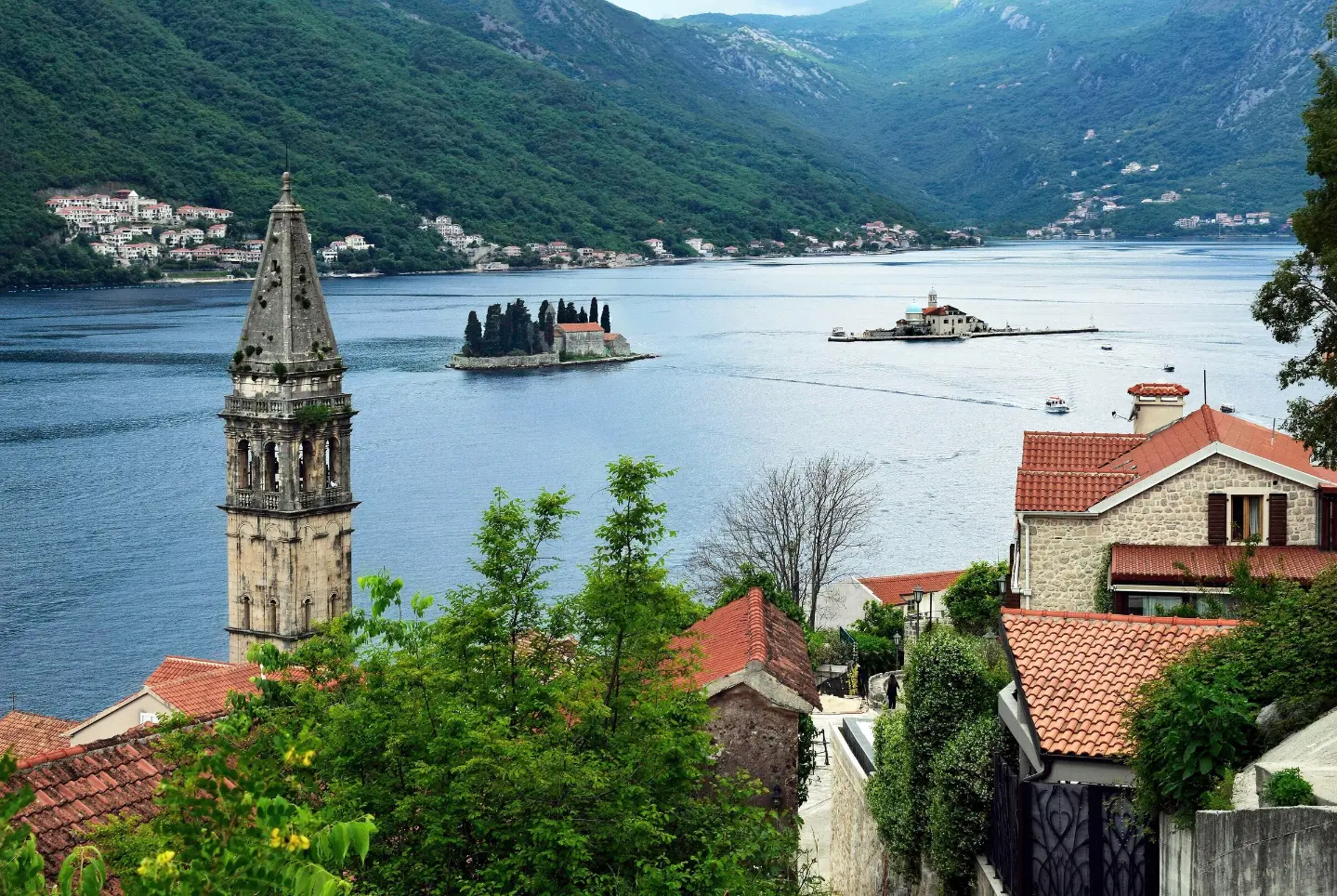 Our Lady of the Rocks and Sveti Đorđe seen past the bell tower of St Nicholas in Perast