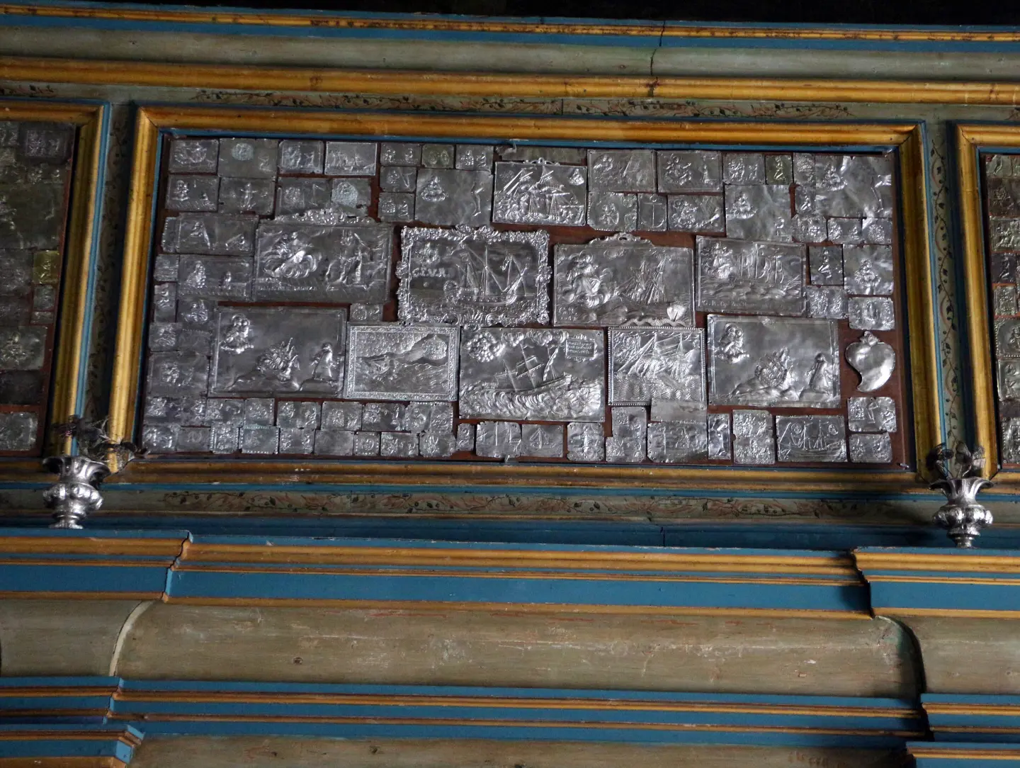 Silver votive plaques on the church wall